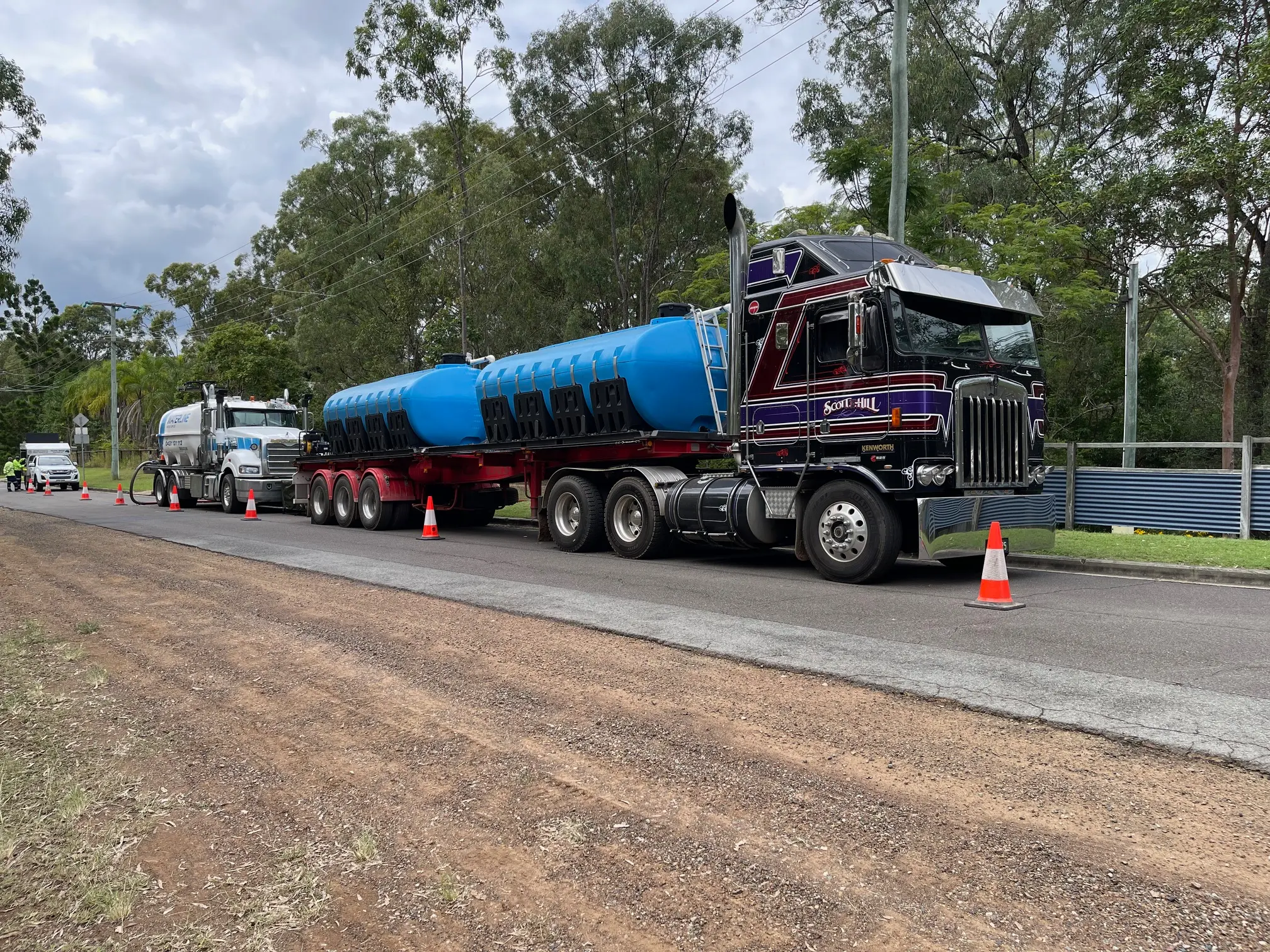 S.T.H Water delivery truck with blue tanks parked on a rural Brisbane road, ready for bulk water transport. Bulk Water Delivery to Brisbane.